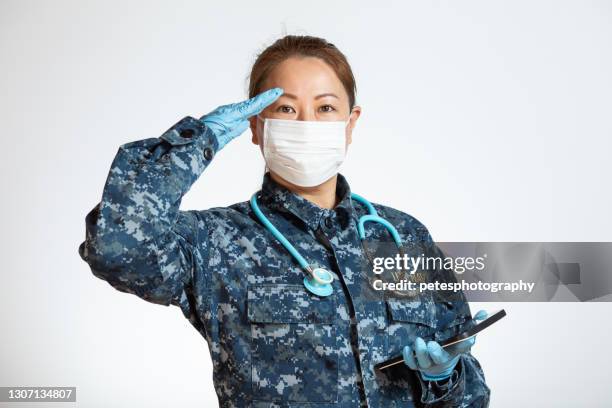 navy doctor or nurse saluting on a white background - doctor saluting stock pictures, royalty-free photos & images