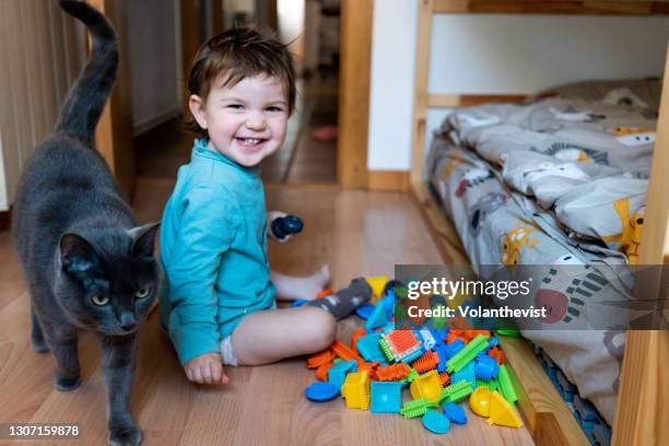 baby playing at bedroom with colorful construction pieces sittion on the floor - bunkbed stock pictures, royalty-free photos & images