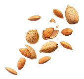Group of almonds splashing over white background