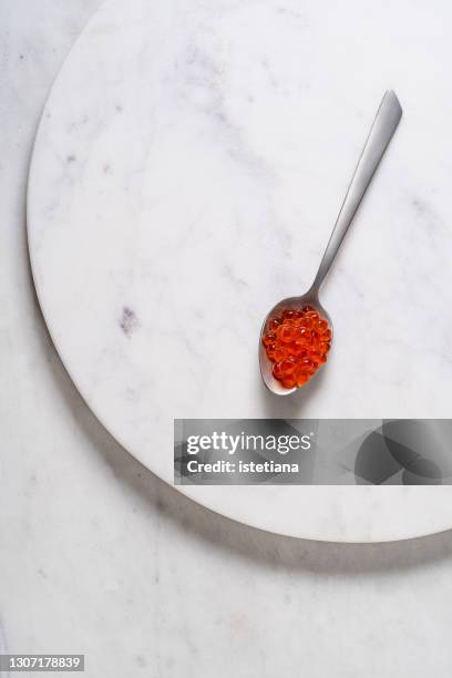 red caviar on spoon on white stone tray - red caviar stock pictures, royalty-free photos & images