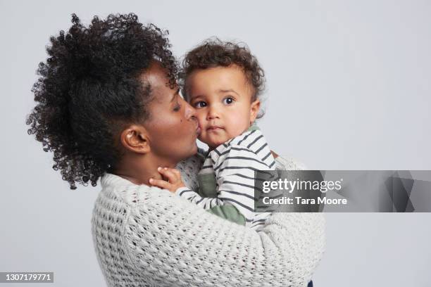 mother cuddling toddler - black mom photos et images de collection