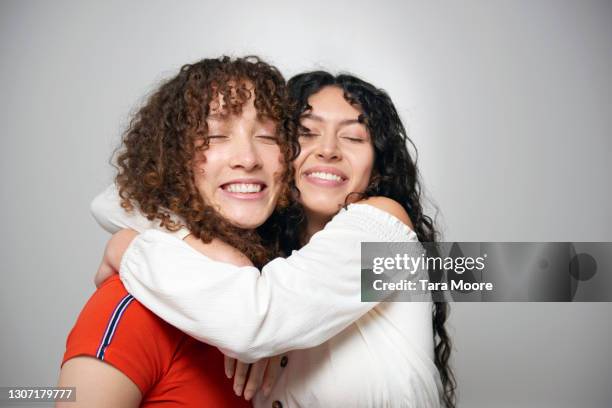 two friends hugging - fond studio stock pictures, royalty-free photos & images