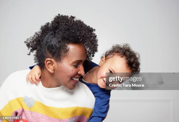 mum piggy backing toddler - woman son stock pictures, royalty-free photos & images