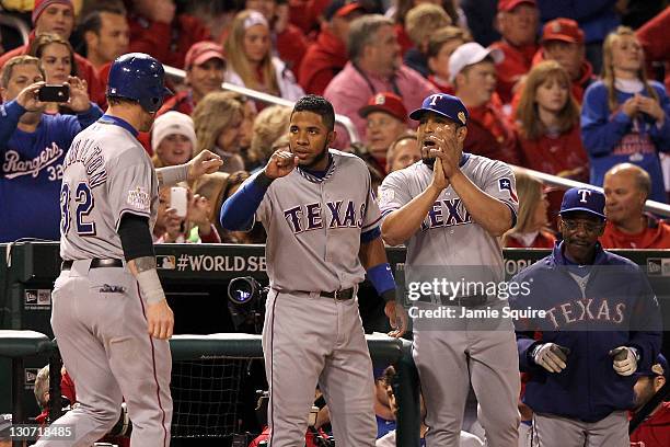 Josh Hamilton of the Texas Rangers celebrates with Elvis Andrus, Yorvit Torrealba and manager Ron Washington after scoring on an RBI double by...