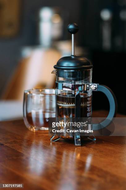 french press and glass with cascara - coffee plunger stock-fotos und bilder