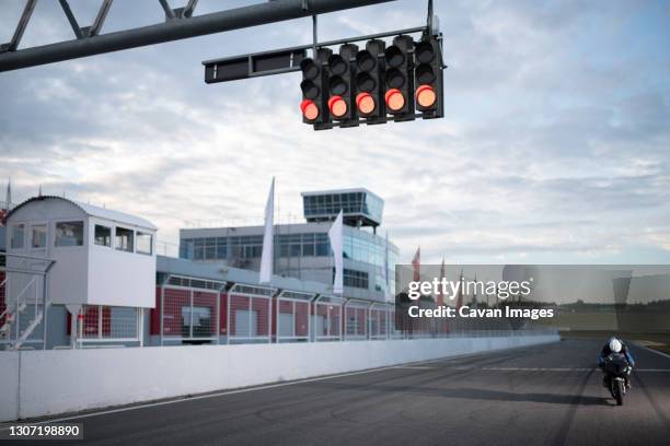 motorcycle racer on start position - motor racing track stockfoto's en -beelden