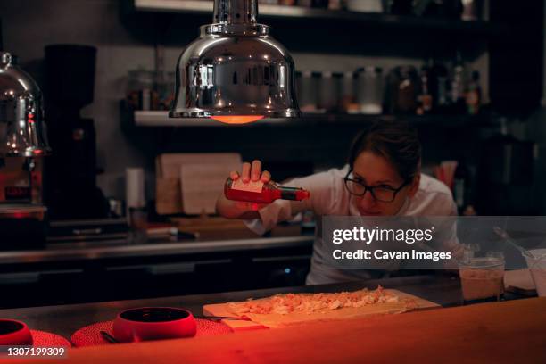 chef preparing food while working with heat lamps in restaurant - infrared lamp stock pictures, royalty-free photos & images