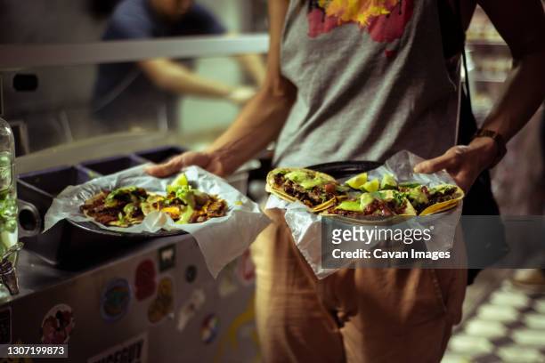 healthy mexican taco street food held by strong healthy tourist - street food fotografías e imágenes de stock