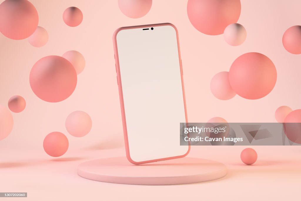 Smartphone with pastel pink floating spheres
