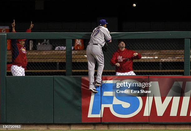 Nelson Cruz of the Texas Rangers leaps against the wall as David Freese of the St. Louis Cardinals hits a solo home run in the third inning during...