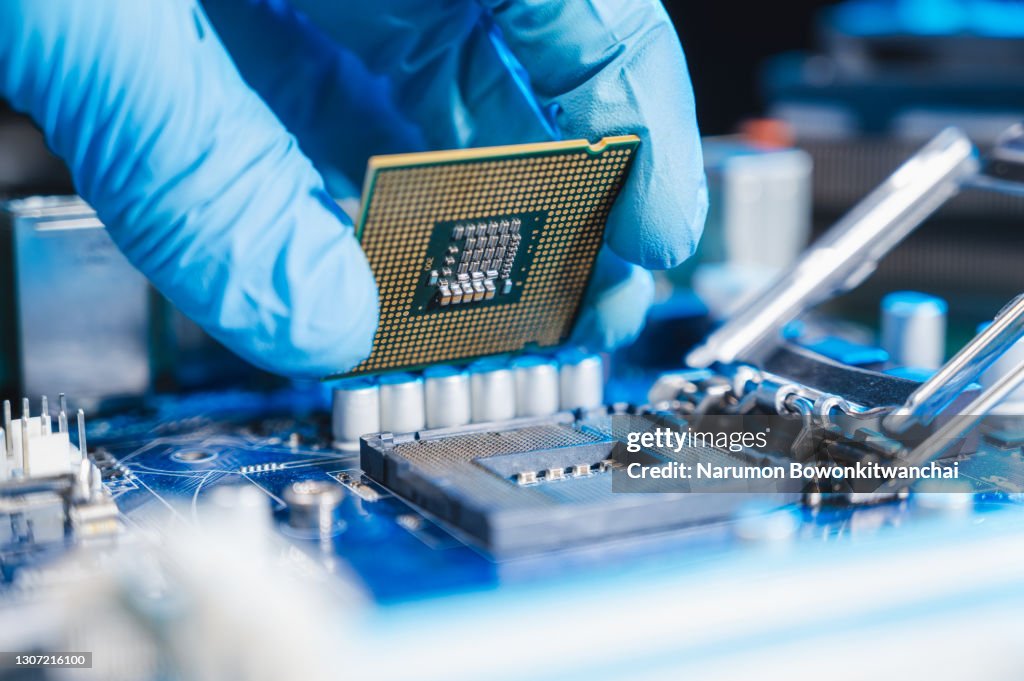 The technician laying CPU in the motherboard socket