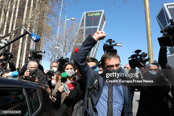 Podemos co-founder Juan Carlos Monedero raises his arm as he leaves the Plaza de Castilla courts after testifying as defendant for alleged irregular...