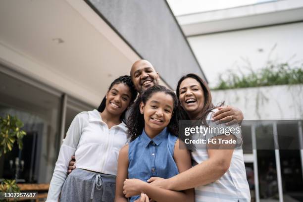 verticale d’une famille heureuse devant la maison - brazilian ethnicity photos et images de collection