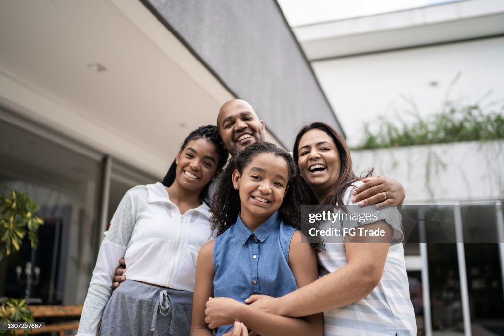 Portrait of a happy family in front of house