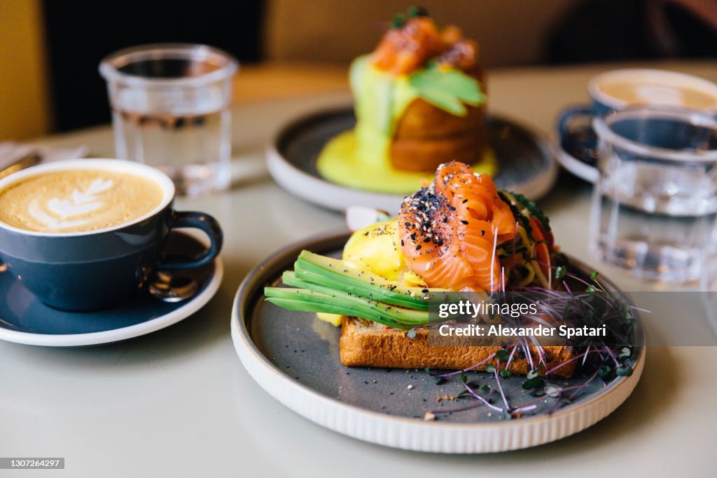 Avocado toast with salmon and poached egg served for breakfast at a cafe