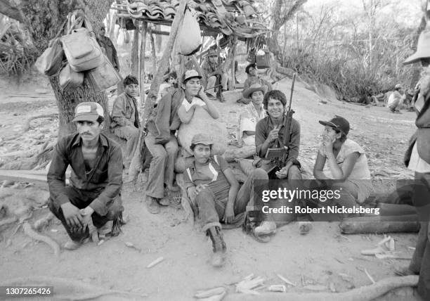 Fuerzas Populares de Liberacion guerrillas sit with a prisoner , suspected of being involved with a death squad, Santa Anita, Chalatenango...