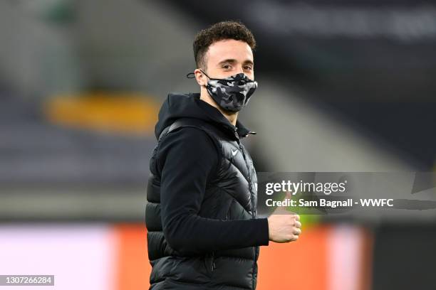 Diogo Jota of Liverpool is seen wearing a face mask as he inspects the pitch prior to the Premier League match between Wolverhampton Wanderers and...