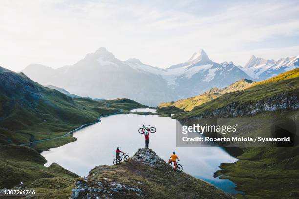 mountain bikers admiring bachalpsee lake, switzerland - freizeitaktivität stock-fotos und bilder