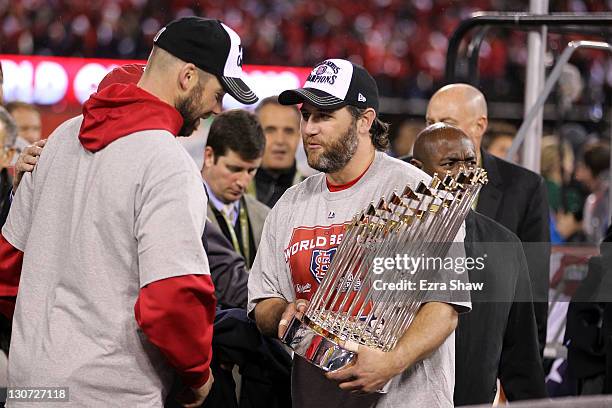 Lance Berkman and Chris Carpenter of the St. Louis Cardinals hold the World Series trophy after defeating the Texas Rangers 6-2 in Game Seven of the...