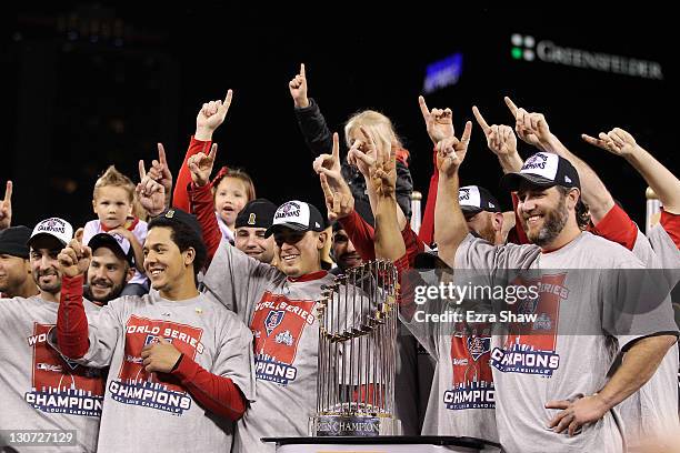 Jon Jay, Allen Craig and Lance Berkman of the St. Louis Cardinals celebrate with the World Series trophy after defeating the Texas Rangers 6-2 to win...