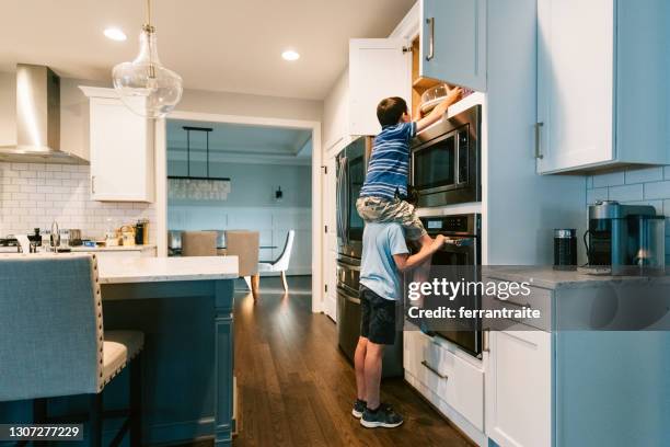 kid carrying friend on shoulders - kitchen fridge imagens e fotografias de stock