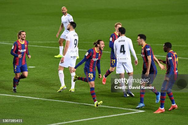 Oscar Mingueza of FC Barcelona celebrates with team mates Sergio Busquets and Ousmane Dembele after scoring their side's third goal during the La...