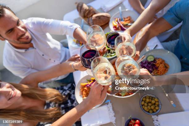 group of friends having a meal outdoors. they are celebrating with a toast using wine. - spain wine stock pictures, royalty-free photos & images