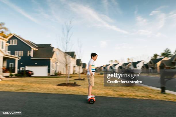 menino montando hoverboard na calçada - hoverboard - fotografias e filmes do acervo