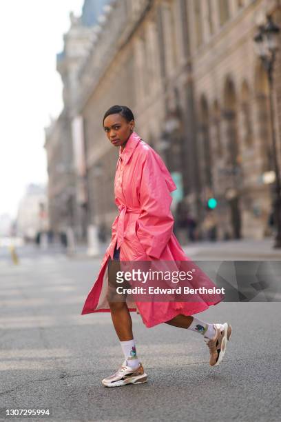 Emilie Joseph @in_fashionwetrust wears a neon pink long trench shiny coat from Margiela, white wool socks with the printed cartoon "Denver The Last...