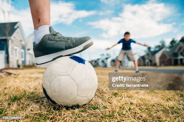 kids playing soccer on the front yard - teasing stock pictures, royalty-free photos & images