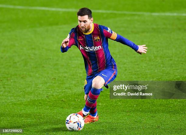 Lionel Messi of FC Barcelona runs with the ball during the La Liga Santander match between FC Barcelona and SD Huesca at Camp Nou on March 15, 2021...