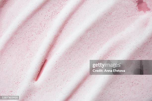 texture of white foam on rose background. selfcare is a trendy procedure of the year. cosmetics banner with copy space - mousse photos et images de collection
