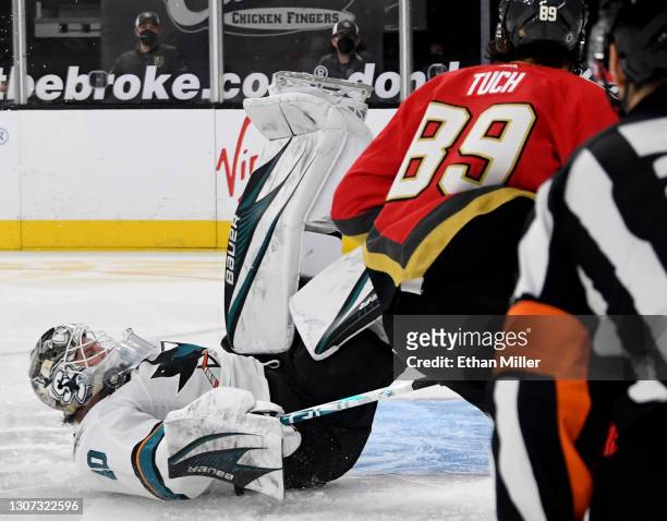 Devan Dubnyk of the San Jose Sharks gets the puck caught in his throat protector after blocking a shot by Alex Tuch of the Vegas Golden Knights in...
