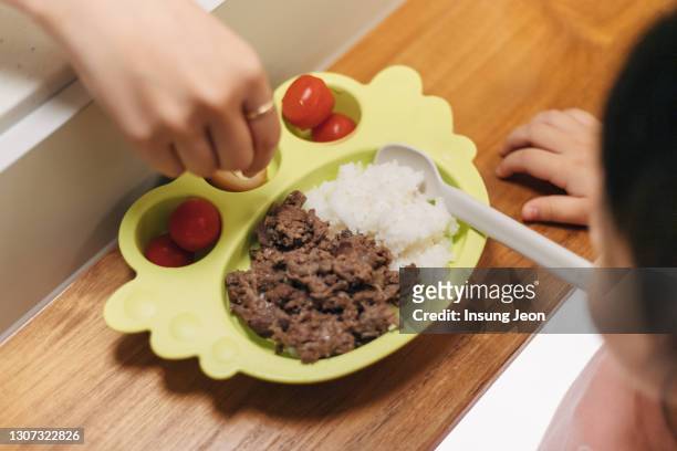 little girl eating bulgogi rice bowl at the dining table - kid boiled egg stock pictures, royalty-free photos & images