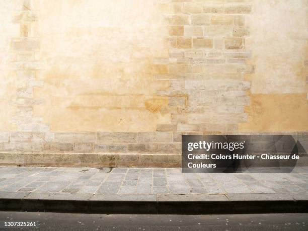 empty haussmann facade with paved sidewalk and street in paris - stenen muur stockfoto's en -beelden