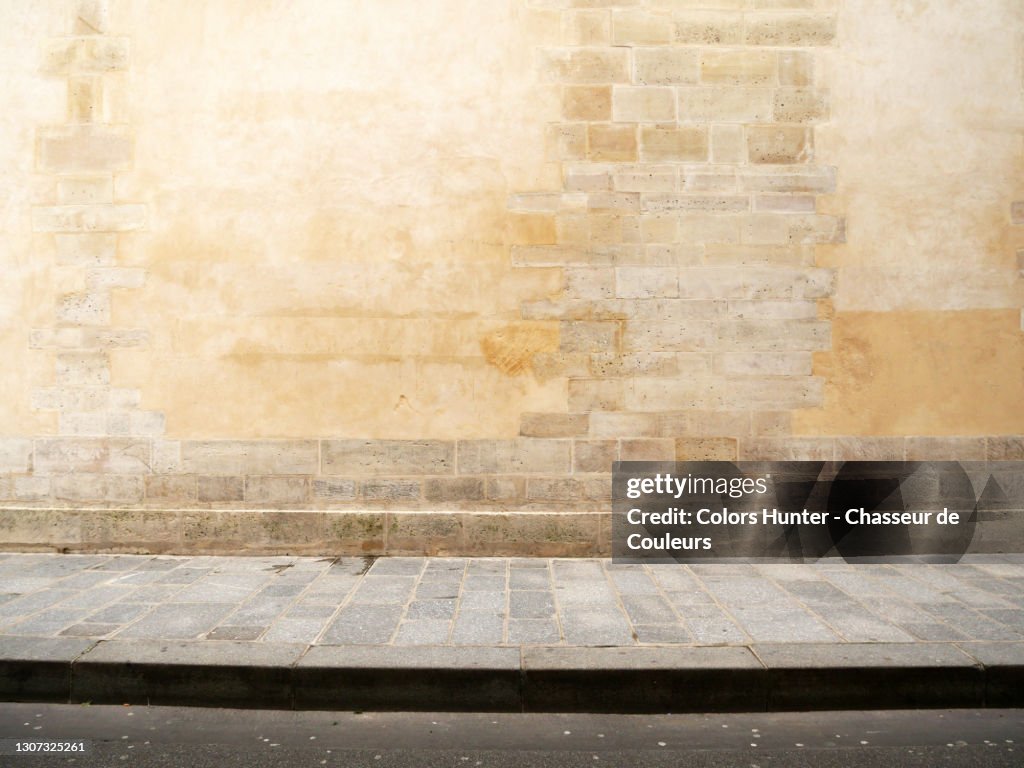 Empty Haussmann facade with paved sidewalk and street in Paris