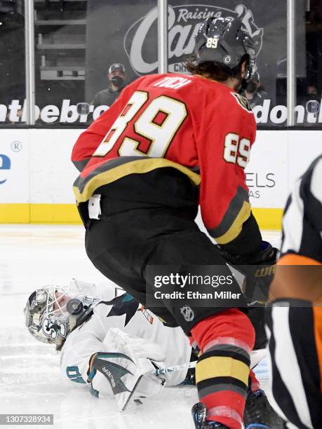 Devan Dubnyk of the San Jose Sharks gets the puck caught in his throat protector after blocking a shot by Alex Tuch of the Vegas Golden Knights in...