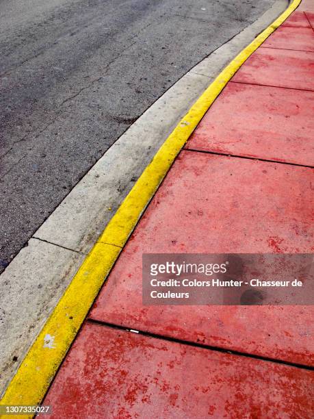 empty sidewalk and street painted and weathered in miami - rinnstein stock-fotos und bilder