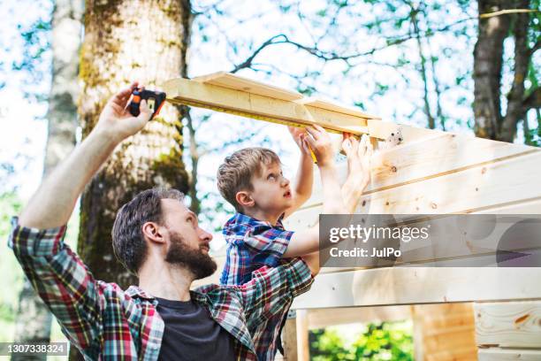 father and son building tree house at backyard - backyard renovation stock pictures, royalty-free photos & images