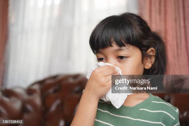 asian kid girl sick with sneezing on nose and cold cough on tissue paper because of influenza and illness or virus bacteria. - japanese girls hot fotografías e imágenes de stock