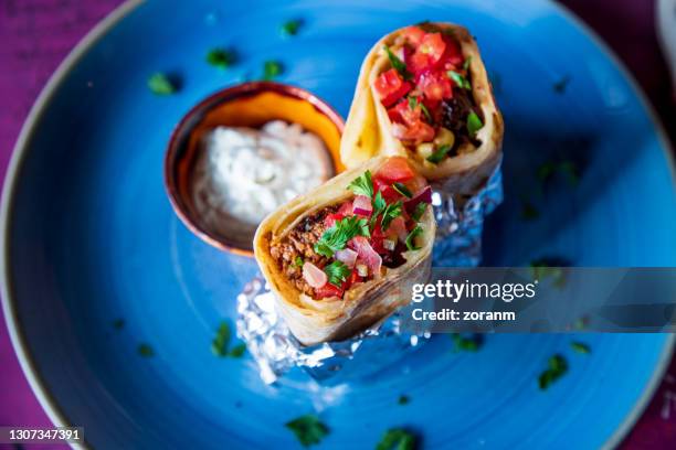 burritos stuffed with ground beef and vegetables on a plate - tortilla stock pictures, royalty-free photos & images