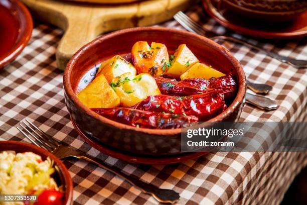 gevulde droge rode peper met gebakken aardappel die in aardewerkkom wordt gediend - gepofte-aardappel stockfoto's en -beelden
