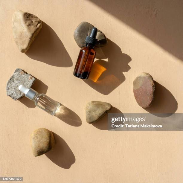top view of face serum bottle on pebble. - brown bottle stock pictures, royalty-free photos & images