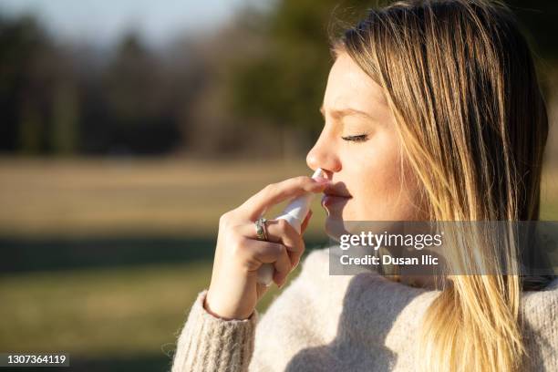 taking nose drops because of pollen allergy - hay fever stock pictures, royalty-free photos & images