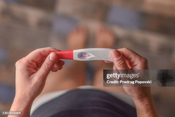 top view , closeup image of a young woman holding negative pregnancy test - infertility stock pictures, royalty-free photos & images