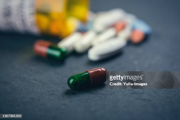 assorted pills spilling from a pharmacy bottle - antiinflamatório imagens e fotografias de stock