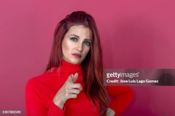 gorgeous young caucasian woman 30-35 years old with red hair staring with serious face and pointing index finger to the front - 30 34 years stock pictures, royalty-free photos & images