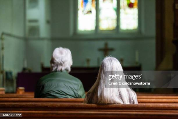 achter mening van twee mensen die in kerk bidden - mis stockfoto's en -beelden