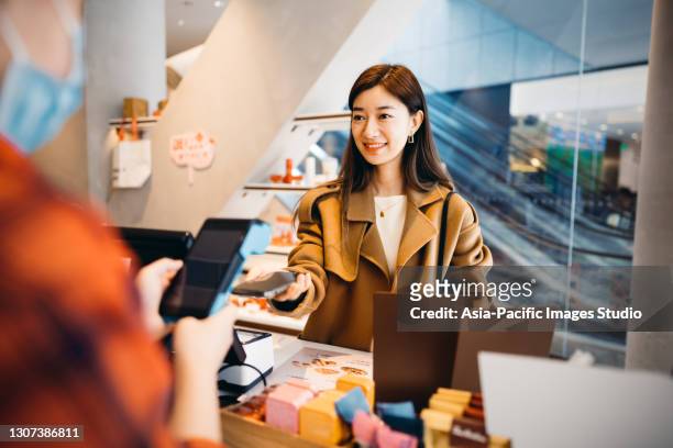 aziatische zakenvrouwen die met smartphone betalen. - bar code stockfoto's en -beelden