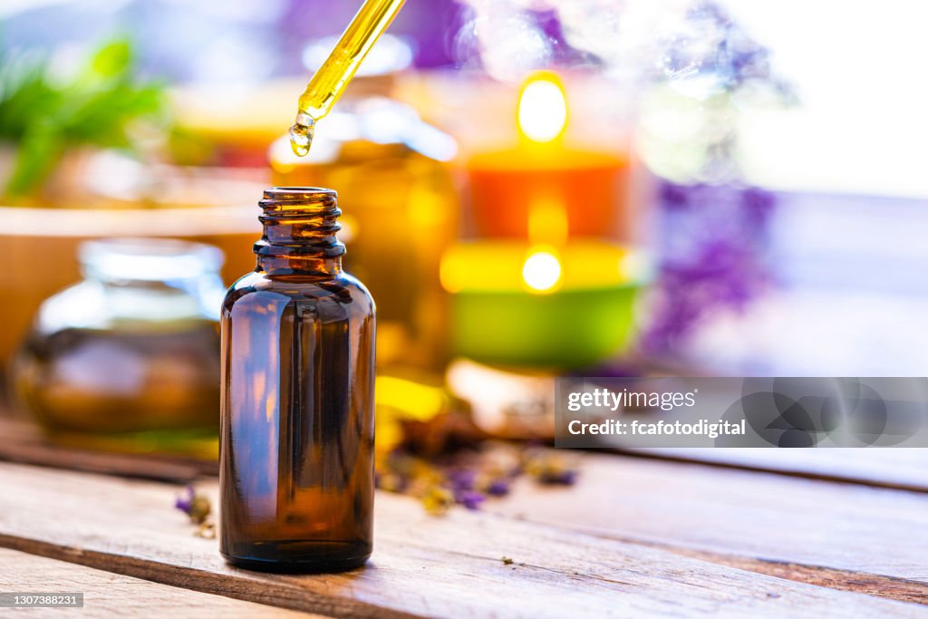 Aromarherapy: botella de aceite esencial sobre mesa de madera